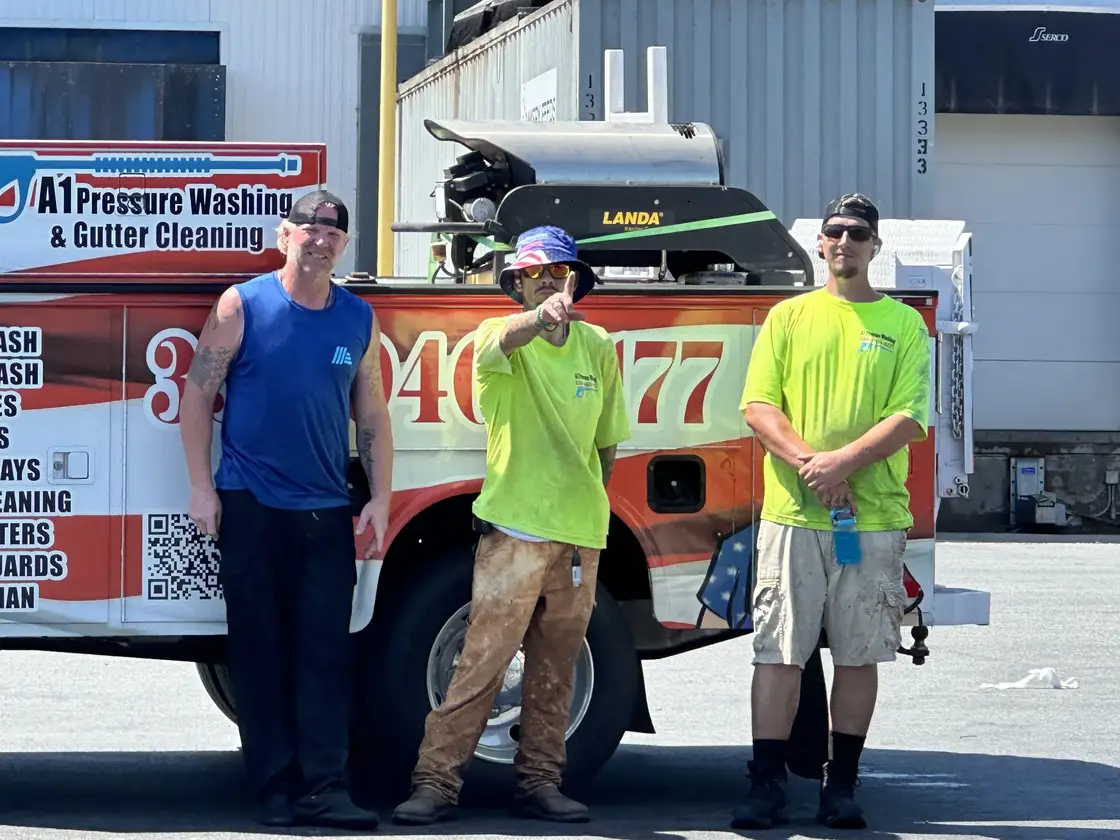 Three A1 crew members standing in front of the lettered company truck