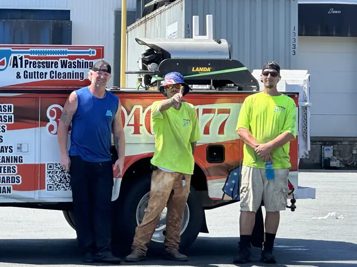 Three A1 crew members standing in front of the lettered company truck