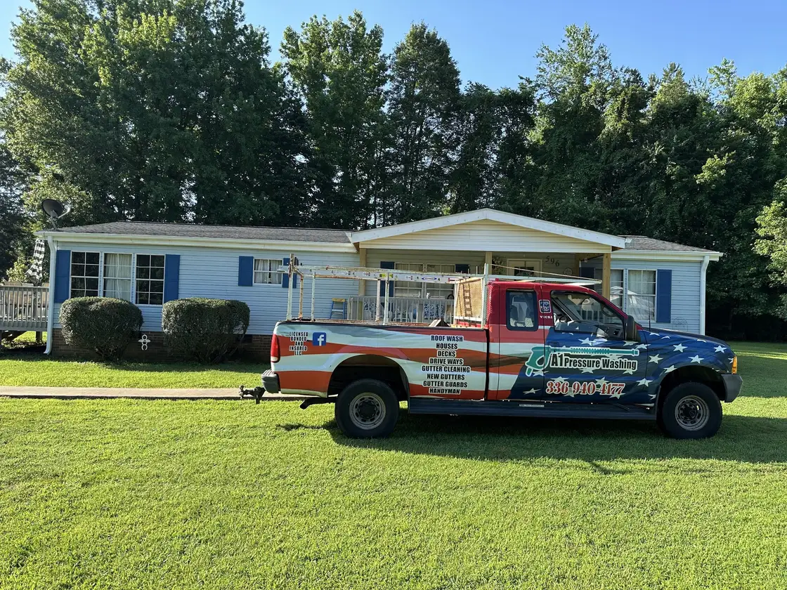 The flag wrapped A1 truck parked on the lawn in front of a white ranch house
